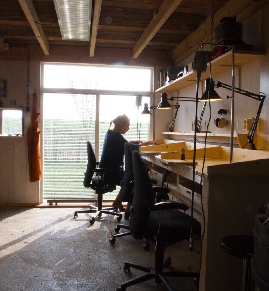 Cursisten aan de werkbanken in het atelier