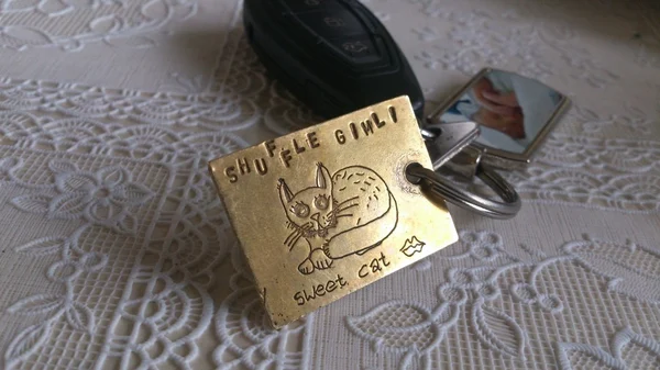 sleutelhanger van messing; geëtste afbeelding/slagletters